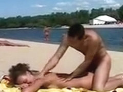 Girl at nudist beach stripping off her clothes and smothered with cream