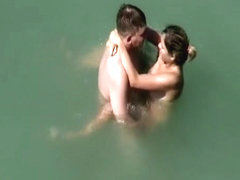 Nudist couple fucks in water
