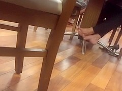 Candid mature barefeet in food court