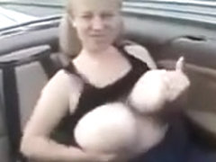 Amateur blonde plays with her huge natural tits in a car
