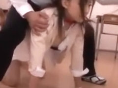 Japanese teacher on all fours in classoom as her students make her come