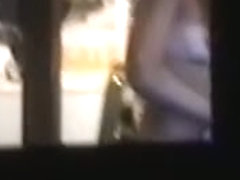 Sexy chick naked on a window voyeur video