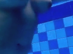 Curvy naked body floats in the pool