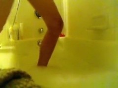 Hot brunette girl masturbates with a dildo and the showerhead in the bathtub